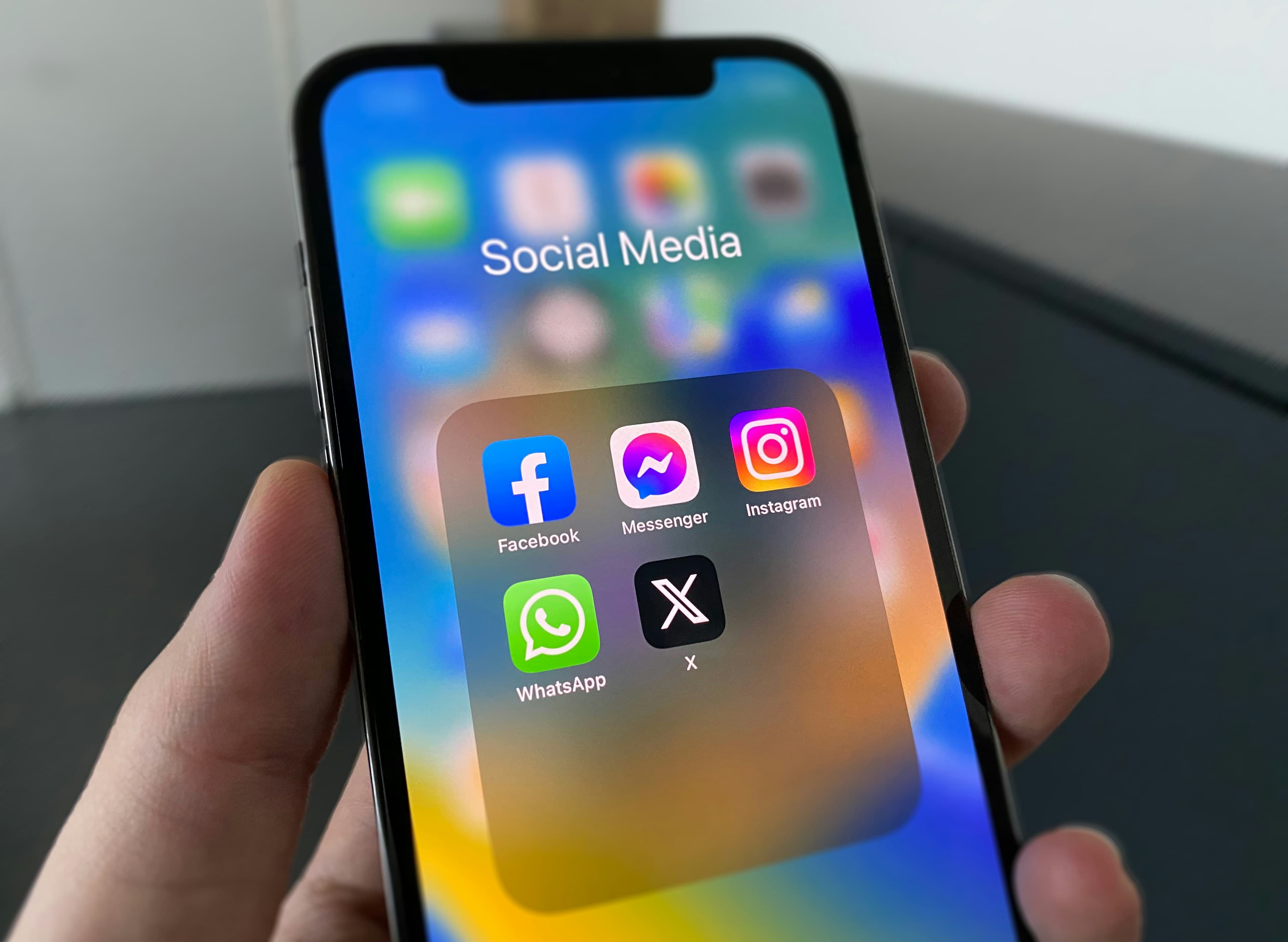 Phone showing a Social Media folder with Facebook, Messenger, Instagram, WhatsApp and X apps